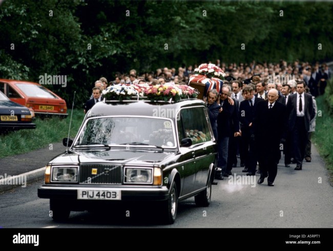 cortege-a-la-suite-d-hommes-portant-le-cercueil-de-marcher-le-long-de-routes-de-campagne-derriere-le-corbillard-lors-des-funerailles-de-l-agent-david-brown-a5rpt1.jpg